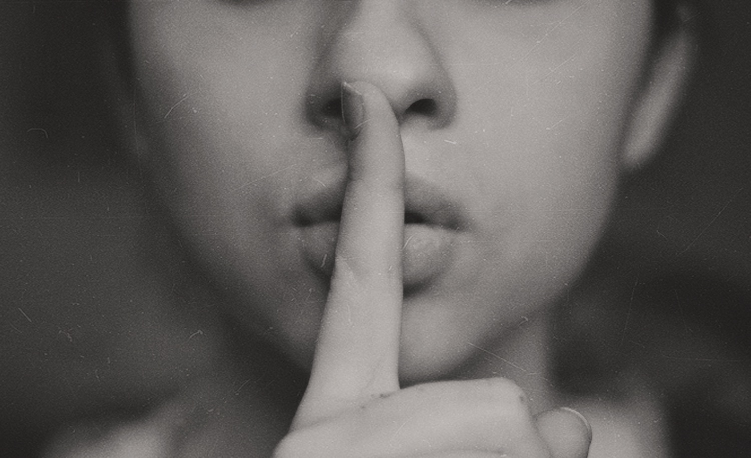An introvert puts a finger to her mouth to ask someone to be quiet.