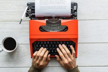 An introvert writes on a typewriter.