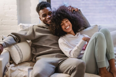 An introvert-extrovert couple relax on the couch