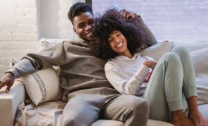 A happy introvert-extrovert couple at home on the couch