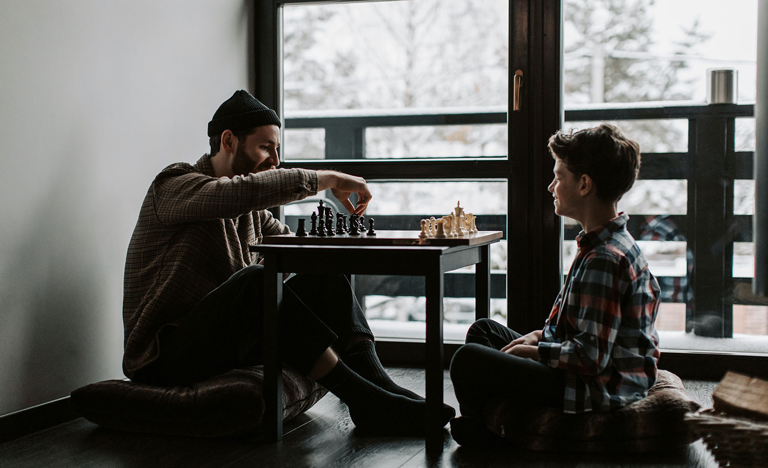 An introverted parent playing chess with his extroverted son