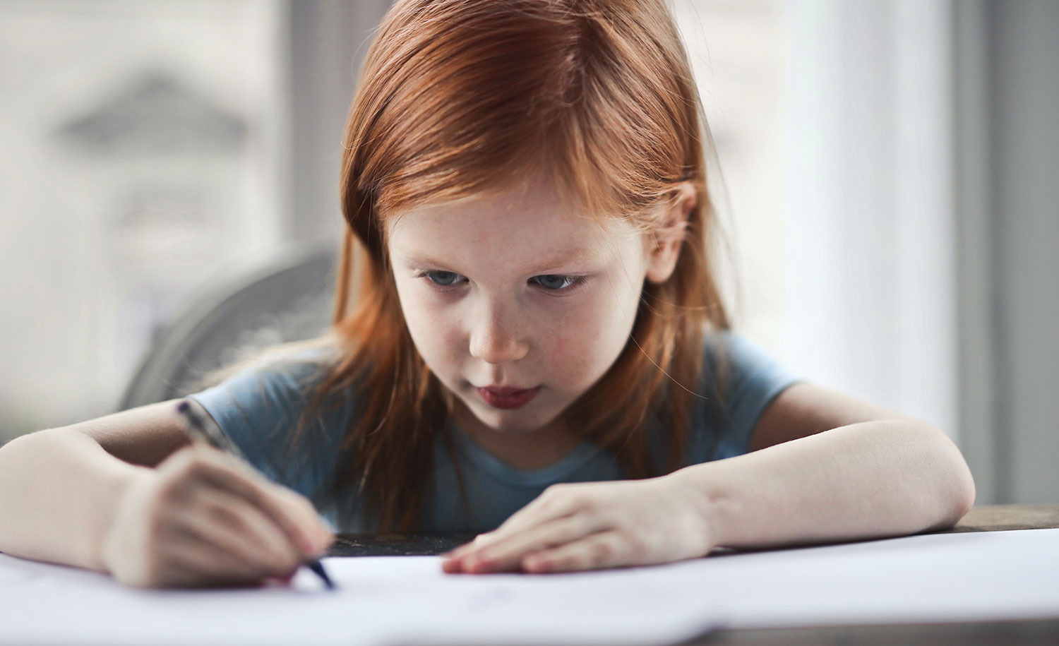 A young girl writes in a notebook