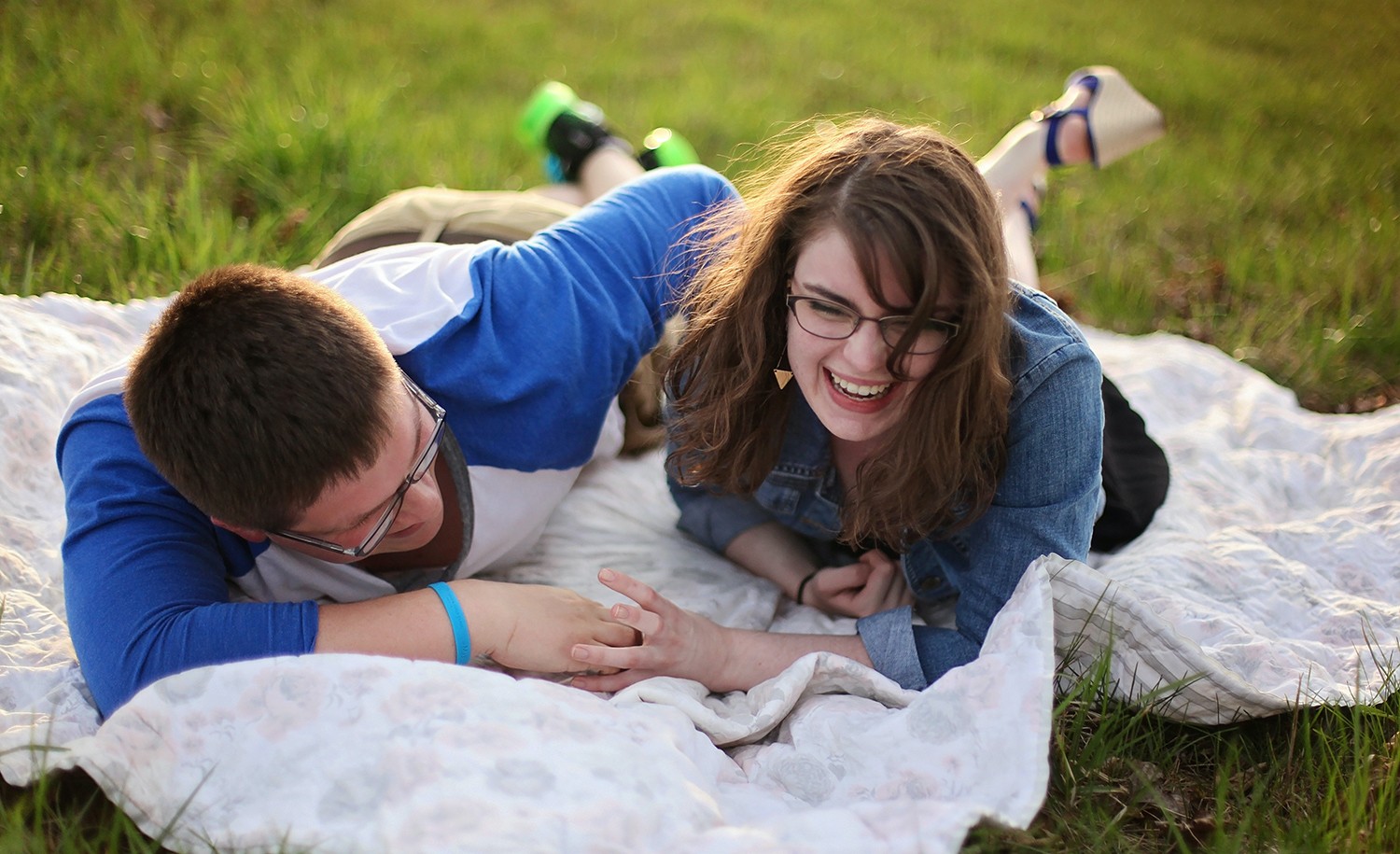 A couple laughing together on a picnic blanket