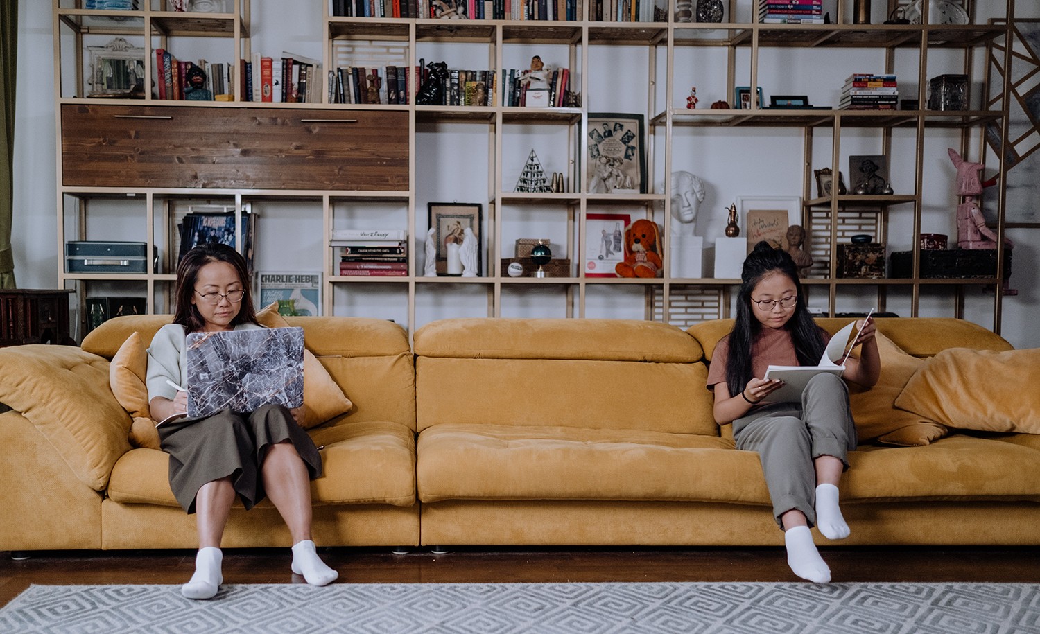 A mother and daughter, who are both introverts, sit far apart on a couch