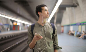 An introvert listens to music as he waits for the train