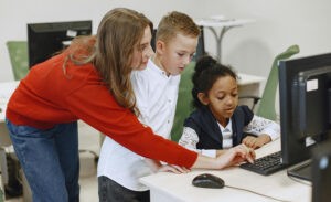An introvert helps kids work on the computer