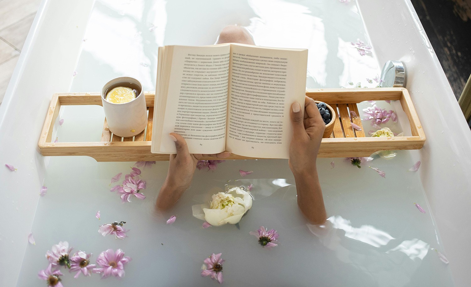 A woman reads a book in the bathtub